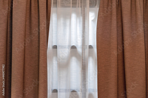 Double-layer curtains in brown blackout fabric and white tulle.