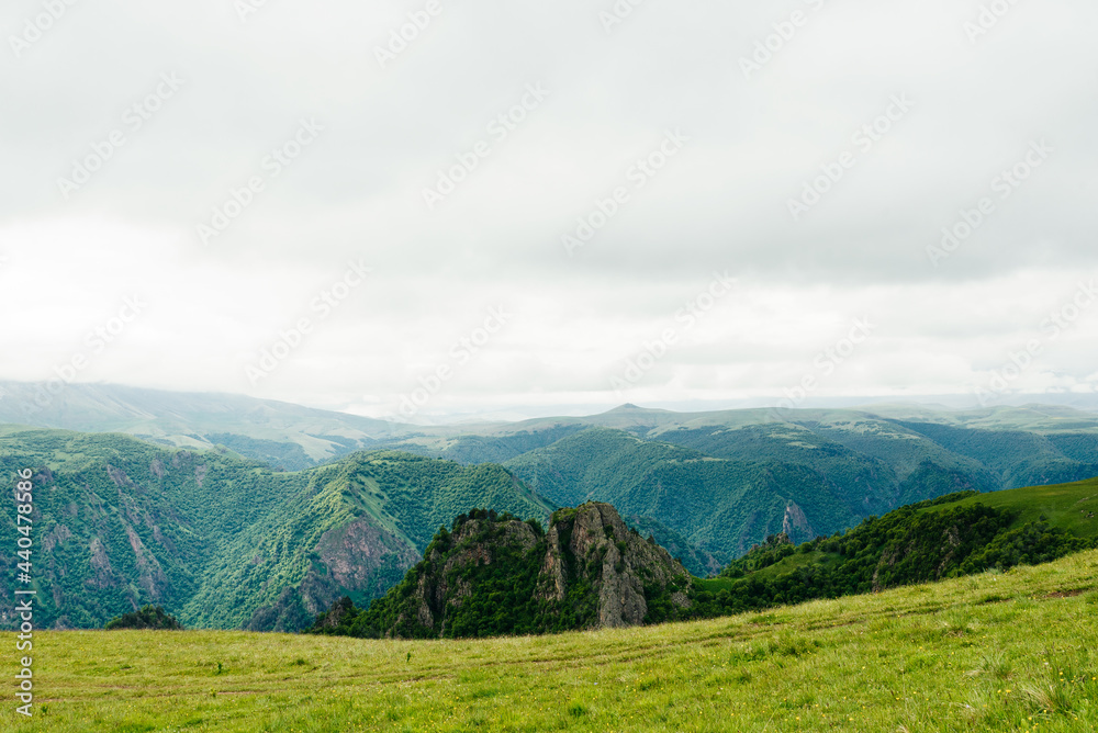 Green fields and mountains of the Caucasus in cloudy weather