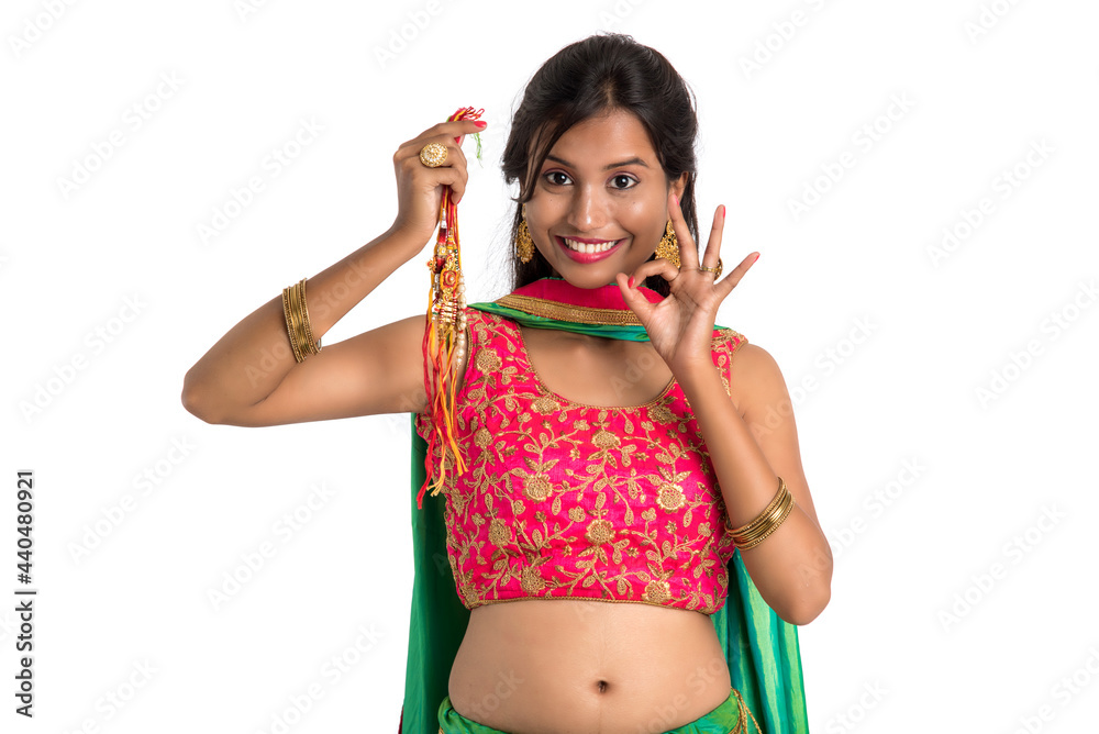 Beautiful girl showing Rakhi on occasion of Raksha bandhan on a white background. Sister tie Rakhi as symbol of intense love for her brother. Beautiful girl showing Rakhi on occasion of Raksha bandhan on a white background. Sister tie Rakhi as symbol of intense love for her brother.