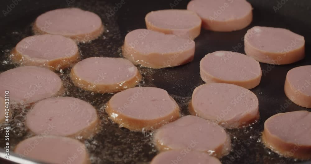 Sausages are fried in oil in a hot pan Sausages are fried in oil in a hot pan