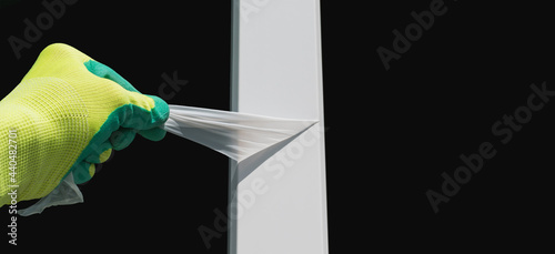 Obraz na plátně The master removes the protective film from the plastic window