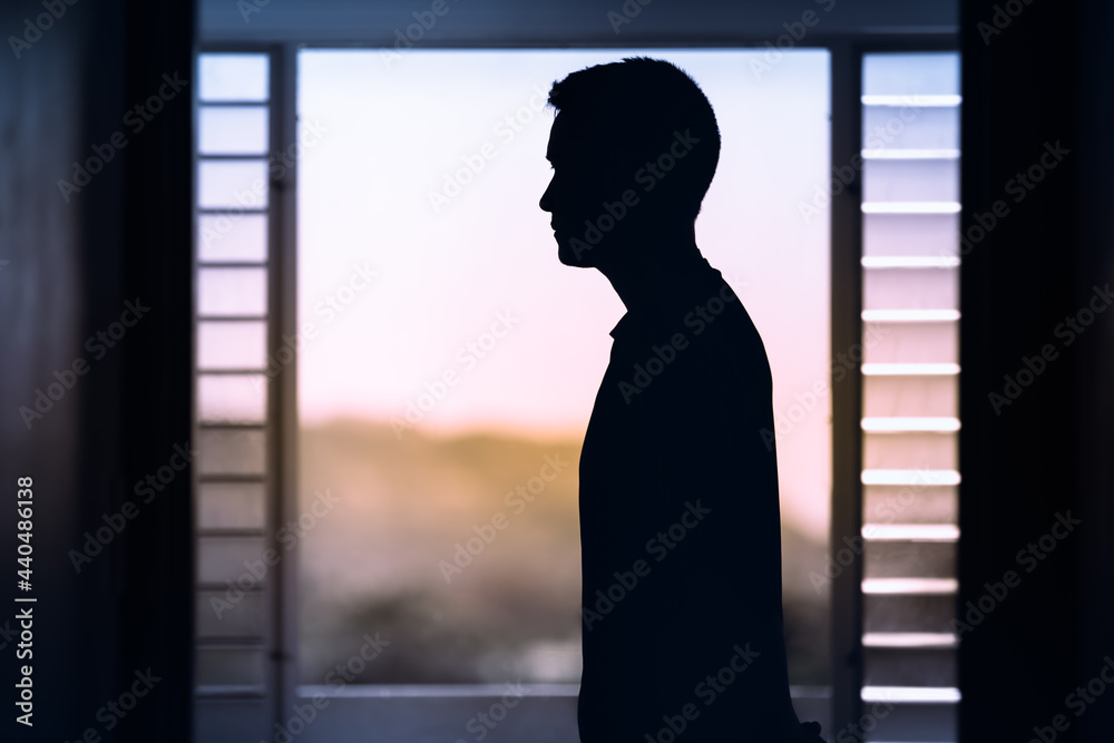 Young thoughtful man looking out his window. Mind and thoughts concept. 