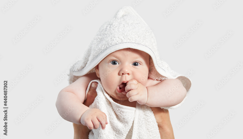 Portrait of a cute baby in a white bath towel on his head after a bath. Newborn care. Mother and child. Advertising of goods for children Portrait of a cute baby in a white bath towel on his head after a bath. Newborn care. Mother and child. Advertising of goods for children