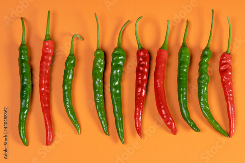 A bunch of red and green chillies placed next to each other.