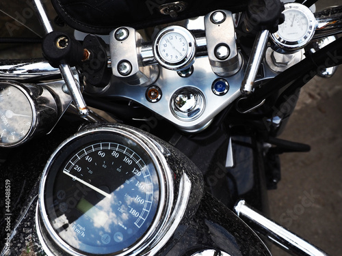 Dashboard of a black motorcycle located on the handlebars and body. Closeup photo