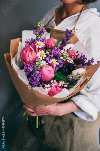 Wallpaper Mural Girl on a dark background stands sideways and holds a bouquet of summer flowers in a paper bag. Florist concept Torontodigital.ca
