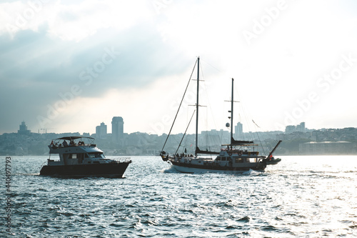 Istanbul, Turkey - June 2021: Two boats at sunset in the Bosphorus. Cultural tours in the Bosphorus in the evening. Istanbul's touristic activities. Selective focus.
