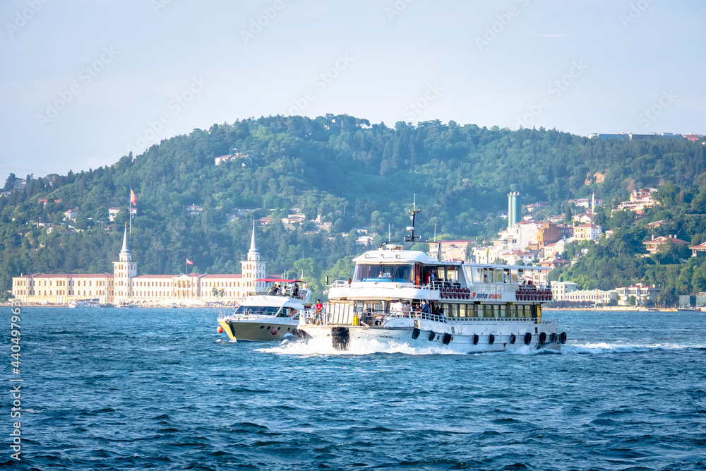 Istanbul, Turkey - June 2021: A ship passing through the Bosphorus. Boat tours in the Bosphorus. Touristic places to visit in Istanbul. Istanbul's historical places. Selective focus, close-up.