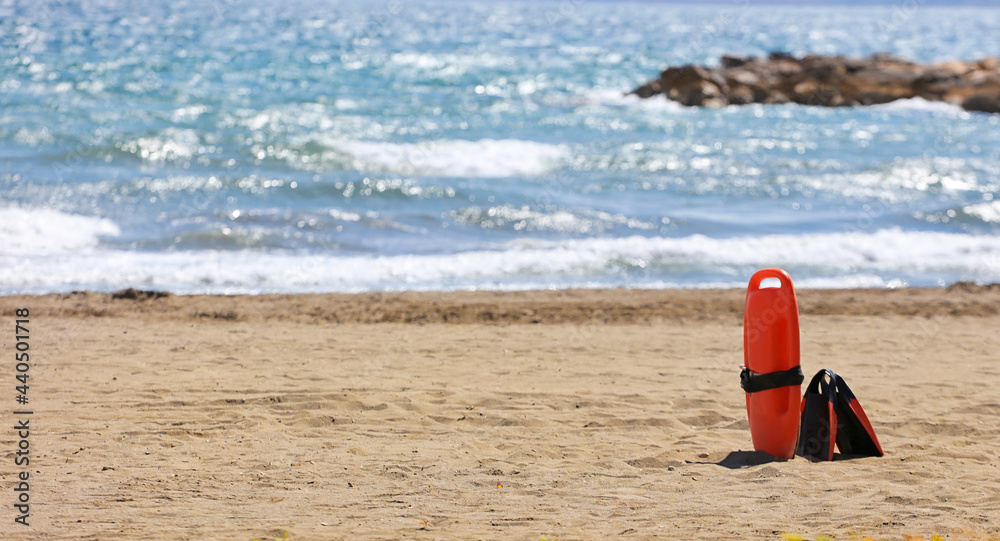 lifeguard rescue equipment beach, on the sand, sea with waves in the background