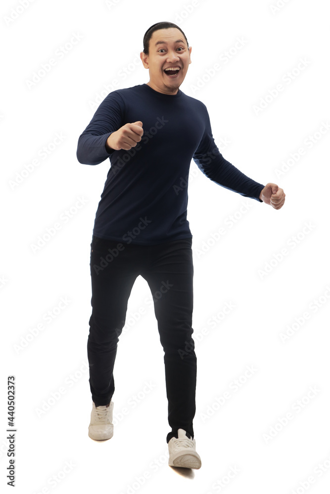 Man wearing casual blue shirt black denim and white shoes, running forward, moving with confidence, front view. Full body portrait isolated