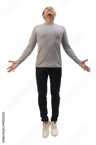 Asian man wearing grey shirt black denim and white shoes, jump flying levitation, happy expression. Full body portrait isolated
