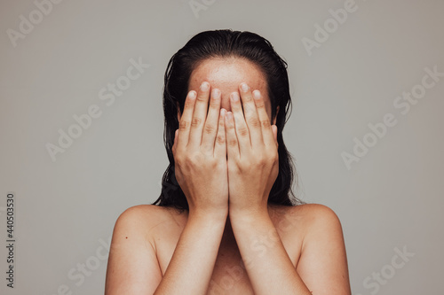 Tablou pe pânză Close up of woman hiding her face with hands
