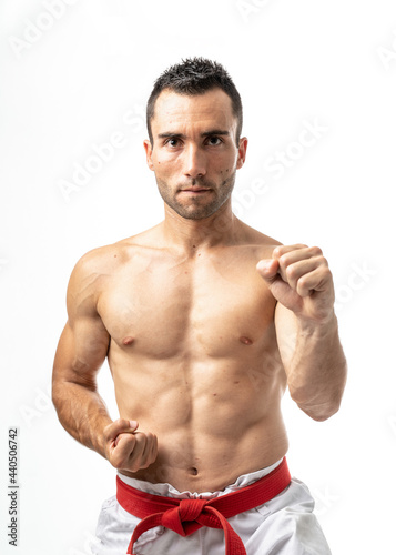 Fit karate fighter practicing katas on white background photo