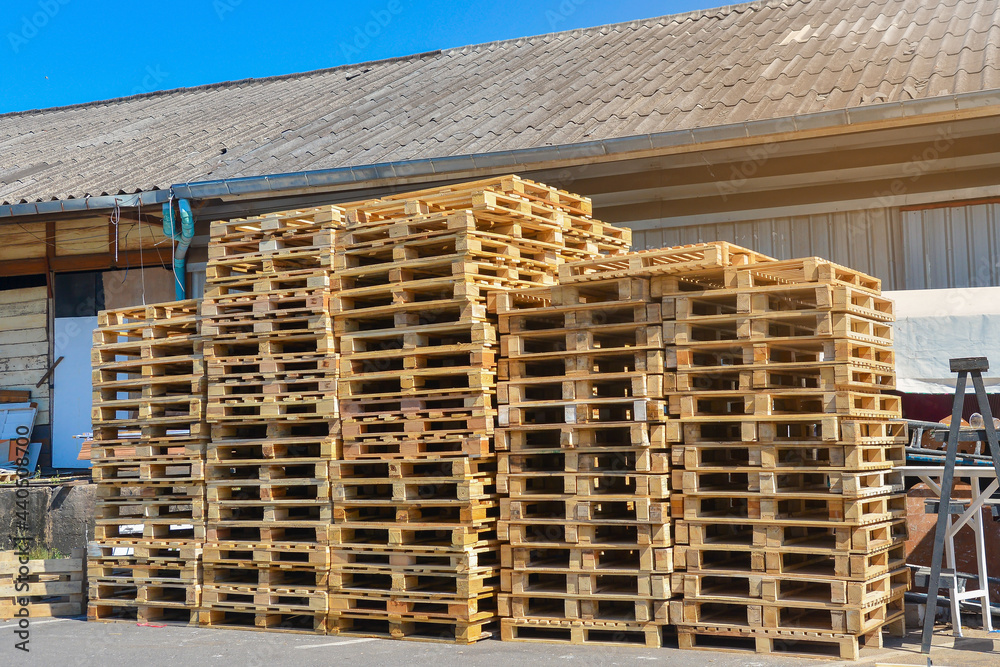 A stack of pallets sit outside a building, Wooden pallet. A stack of pallets sit outside a building, Wooden pallet.