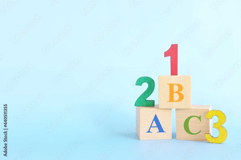 Colorful 123 numbers and abc letters alphabet on wooden blocks in blue background with copy space. Start of child or kid learning counting concept.