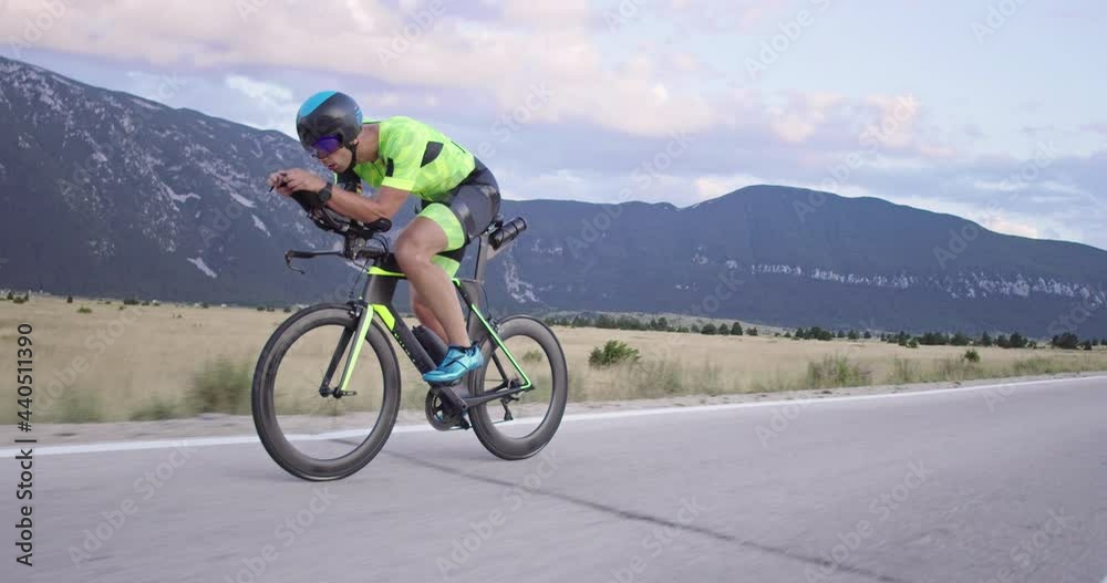 Triathlon sportsman athlete cyclist riding professional racing bicycle. Triathlon sportsman athlete cyclist riding professional racing bicycle.