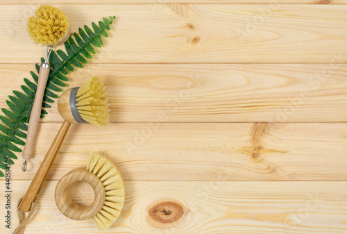 Natural cleaning bamboo, coconut dish brushes on wooden table. Eco friendly with No plastic kitchen and home cleaning. Top view, flat lay. Sustainable lifestyle, Zero waste concept.