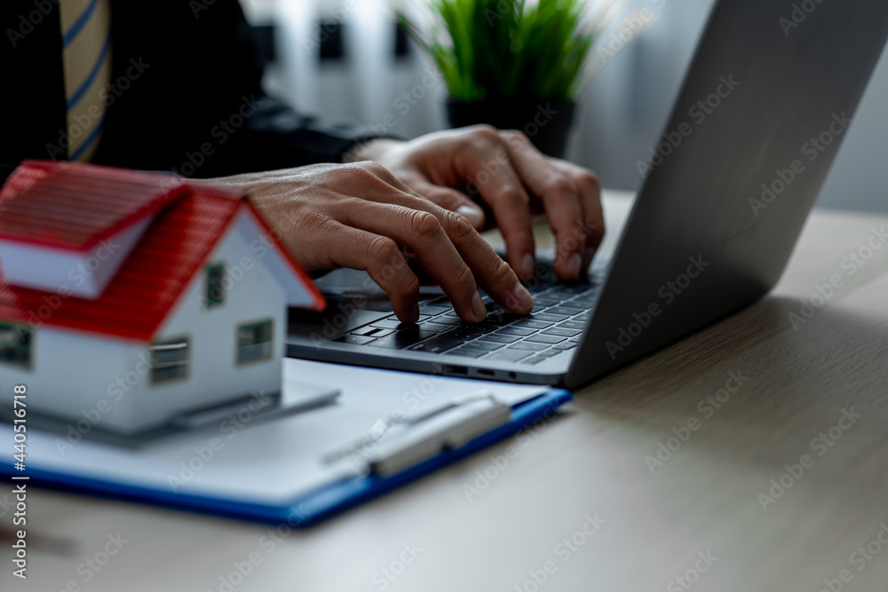 Fototapeta premium House model with real estate agent working at model office,Contracting home loans, home buying planning, business investment planning, business housing.