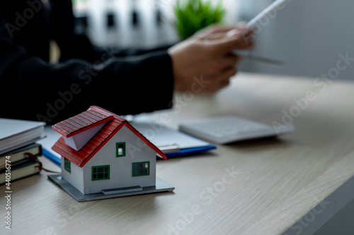 House model with real estate agent working at model office,Contracting home loans, home buying planning, business investment planning, business housing.