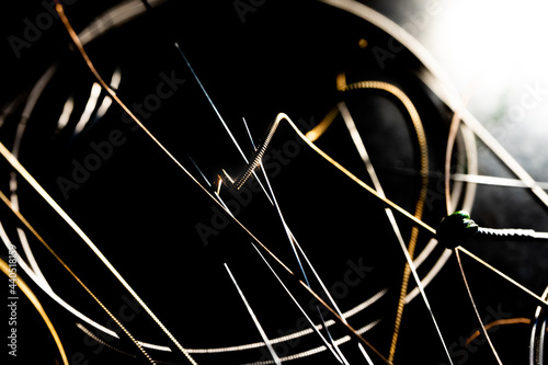 Abstract Closeup of End on Used Bronze Acoustic Guitar String in Front of Other Loose Strings