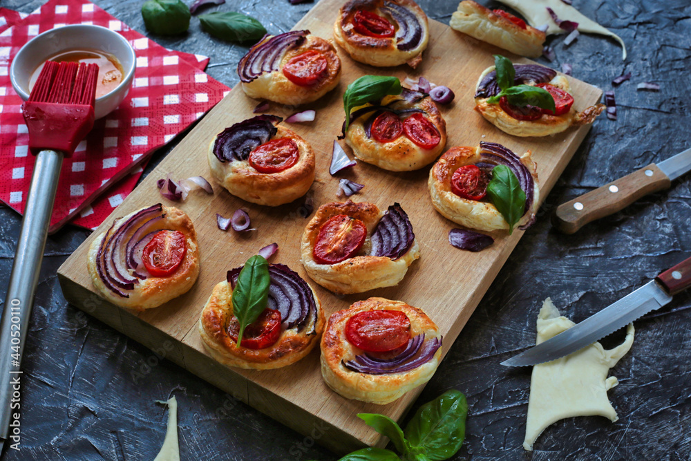 
Delicious and healthy snack made of puff pastry. Tomatoes, cheese, and onion on puff pastry.