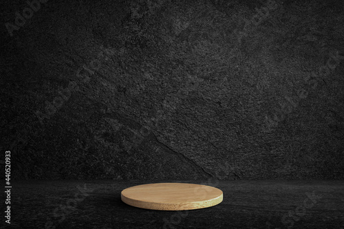 Round wooden product stand on black wall texture rough background dark stone wall or grunge background with black.
