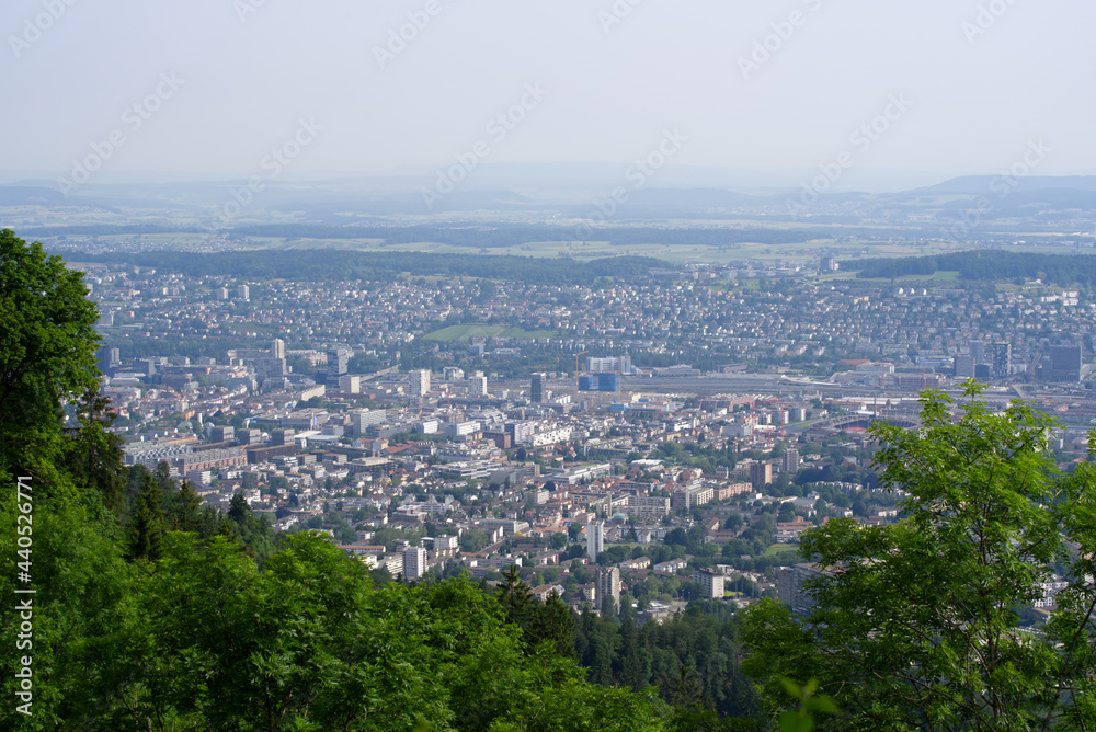 Panoramic view over City of Zurich seen from local mountain Uetliberg on a hazy summer day. Photo taken June 18th, 2021, Zurich, Switzerland.