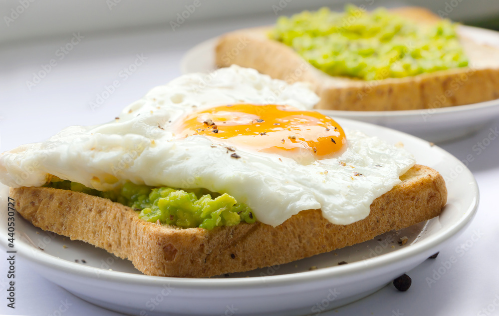 Healthy food. bread with avocado and egg on dish. Avocado toast for breakfast.