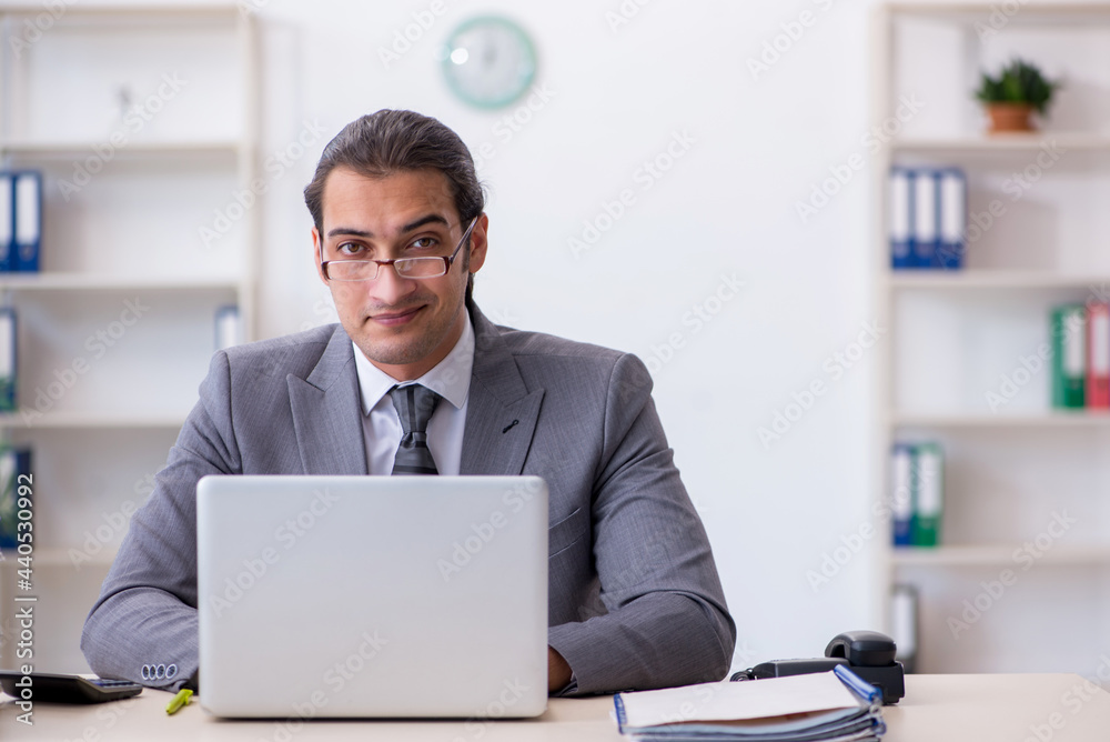 Young male employee unhappy with excessive work in the office Young male employee unhappy with excessive work in the office
