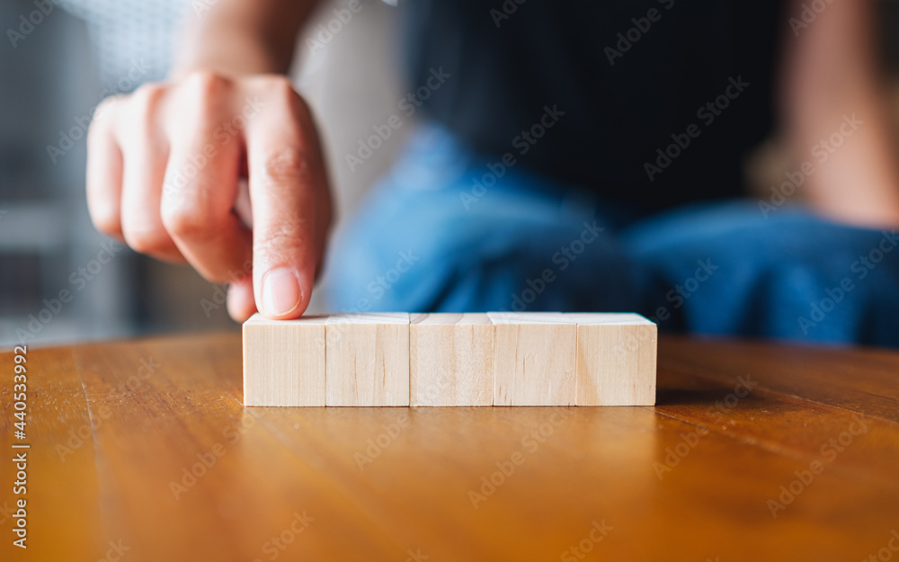 Closeup image of a hand choosing and picking five pieces of blank wooden cube block Closeup image of a hand choosing and picking five pieces of blank wooden cube block