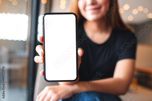 Εκτύπωση καμβά Mockup image of a beautiful asian woman holding and showing a mobile phone with