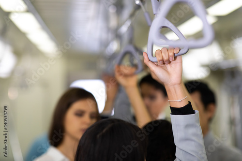 Close up hand Young beautiful woman passenger holding handle while going to working by public sky electric train