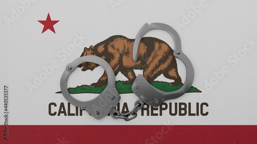 A half opened steel handcuff in center on top of the US state flag of California
