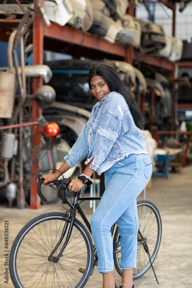Obraz premium Big african american woman modeling. Old Machine auto parts in warehouses. Auto mechanic car service, repair and maintenance concept. used car-auto mobile spare parts
