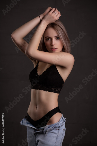 Young beautiful girl in sexy underwear, on a dark background