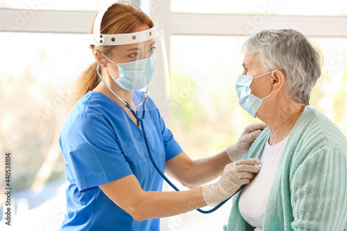 Doctor examining senior wom...