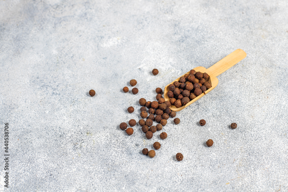 Allspice in a small bowl and spoon. Allspice in a small bowl and spoon.