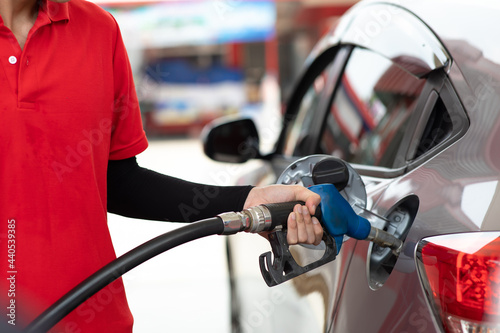 Man worker hand holding nozzle and refuel the car