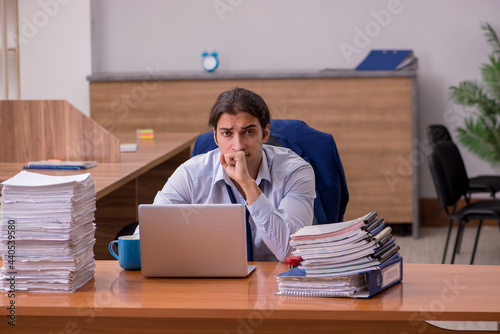 Young male employee unhappy with excessive work in the office © Elnur
