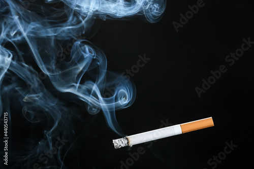 Burning cigarette on dark background