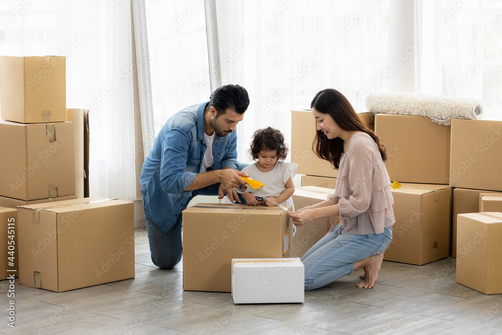 The family just bought new furniture and helped organize the house. Mon dad and daughter just moving new home. They unpacking parcel box and arranging on the floor in the living room. The family just bought new furniture and helped organize the house. Mon dad and daughter just moving new home. They unpacking parcel box and arranging on the floor in the living room.