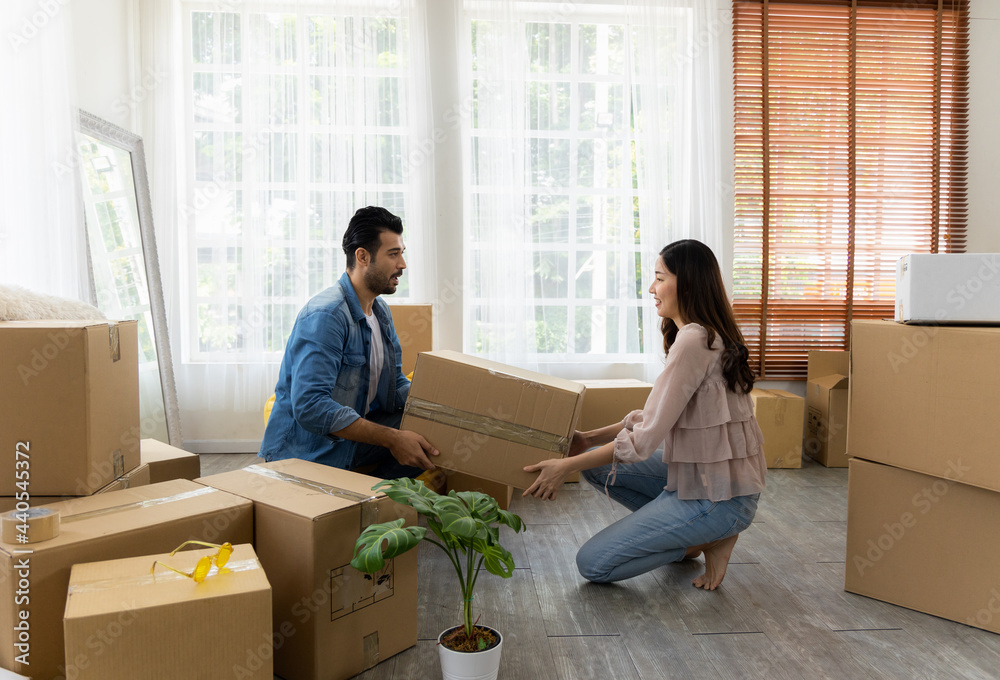 The family just bought new furniture and helped organize the house. Husband and wife just moving new home. They unpacking parcel box and arranging on the floor in the living room. The family just bought new furniture and helped organize the house. Husband and wife just moving new home. They unpacking parcel box and arranging on the floor in the living room.