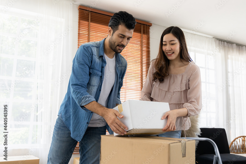 The family just bought new furniture and helped organize the house. Husband and wife just moving new home. They unpacking parcel box and arranging on the floor in the living room. The family just bought new furniture and helped organize the house. Husband and wife just moving new home. They unpacking parcel box and arranging on the floor in the living room.
