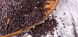 Black rice on old wooden table. Selective focus