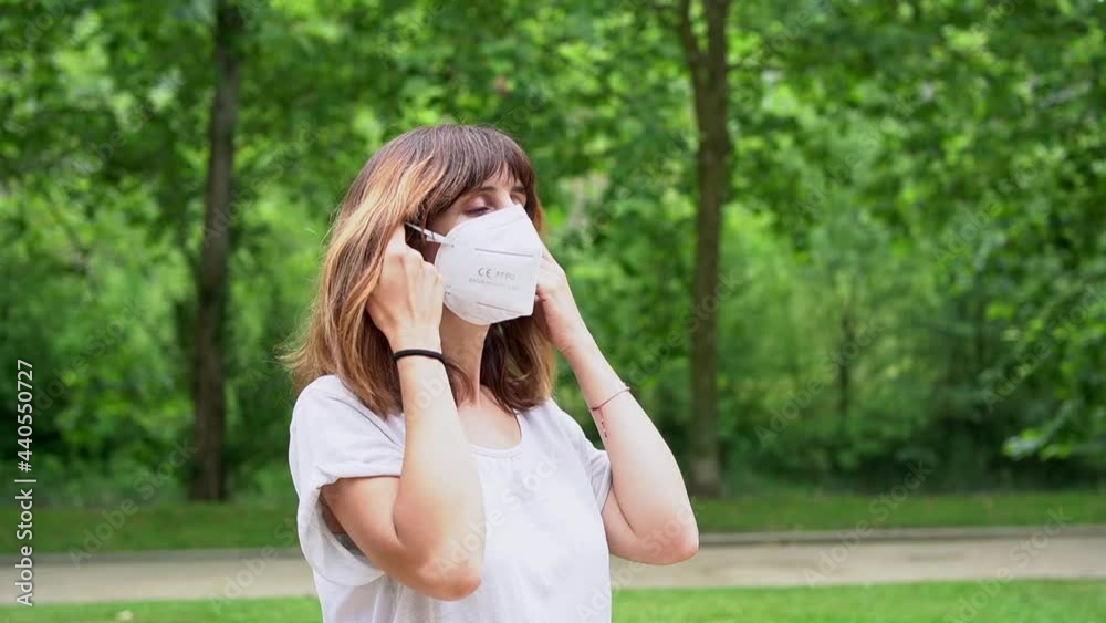 A young woman removing her surgical mask and smiling at the end of the coronavirus pandemic. End of restrictions abroad, happy to be able to breathe well again, covid19 A young woman removing her surgical mask and smiling at the end of the coronavirus pandemic. End of restrictions abroad, happy to be able to breathe well again, covid19