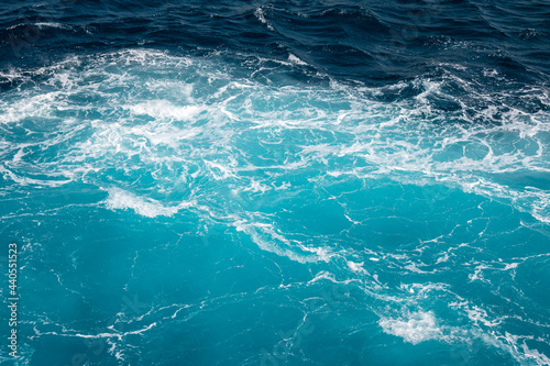 Turquoise ocean water background. Surface of the sea. Natural texture of blue foaming sea water.