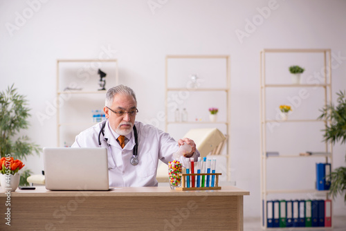 Old male doctor pharmacist working in the clinic