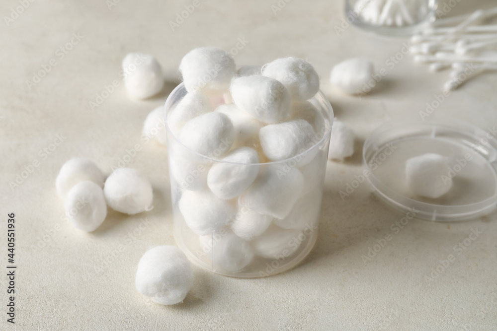 Container with soft cotton wool on light background Container with soft cotton wool on light background