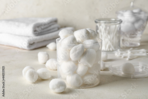Container with soft cotton wool on light background