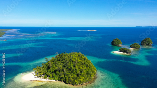 Aerial seascape of a beautiful island with a beach and blue clear water. Britania Islands, Surigao del Sur, Philippines.